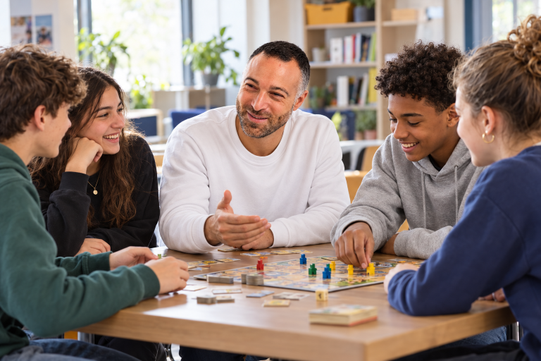 Christophe avec un groupe de jeunes autour d’un jeu de société