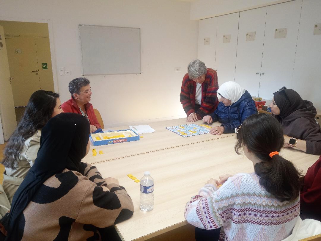 Apprenants et bénévoles autour d’un jeu de lettres.